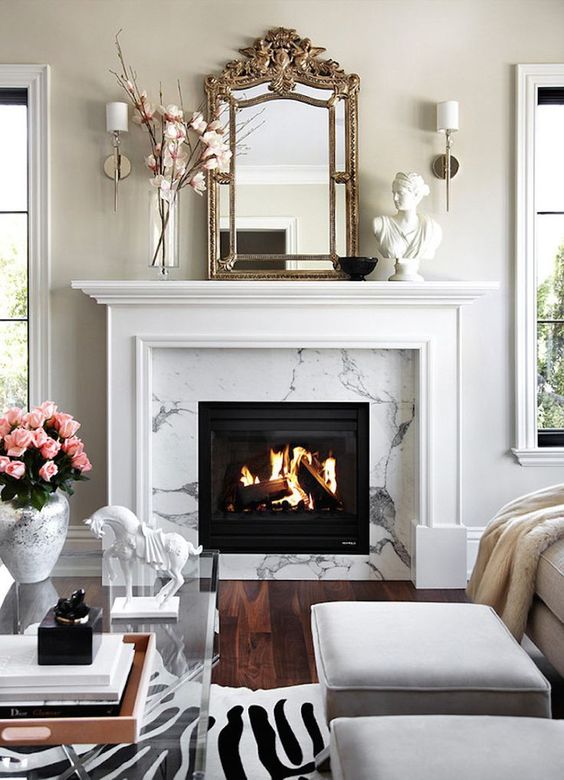 a whimsical living room with a white marble fireplace, a mantel, some decor, a glass coffee table, white poufs anda faux skin rug