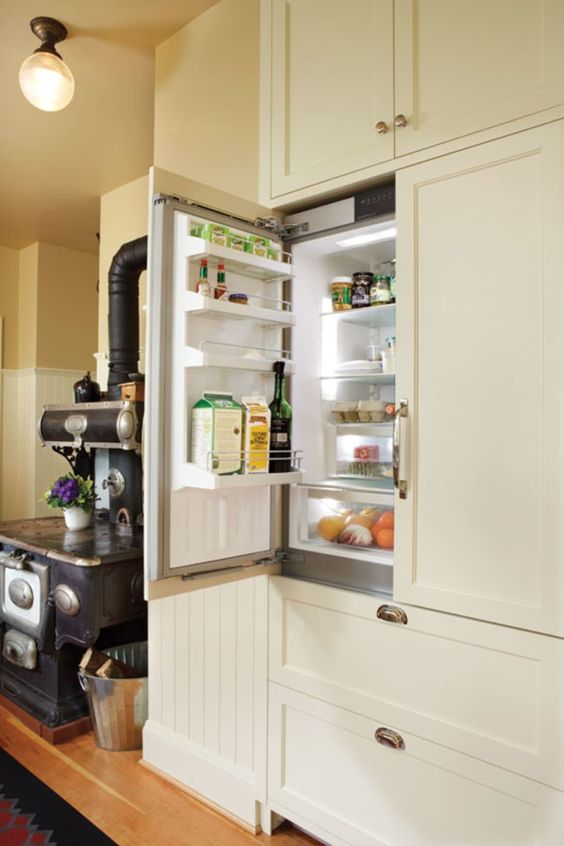 a fridge hidden inside kitchen cabinets to keep the look of the space sleek and elegant, without disturbing the style