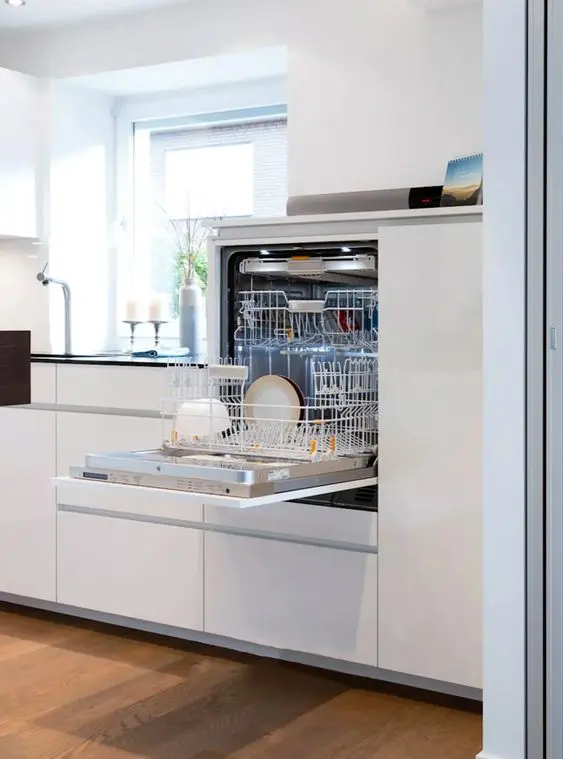 a sleek minimalist white kitchen with a dishwasher hidden inside one of the cabinets to keep the look ultra-minimal