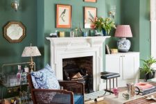 34 an elegant living room with calming green walls, a fireplace with a vintage mantel, a gallery wall and dark and light furniture