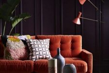 36 a fantastic living room with deep aubergine walls, an orange sofa and lamps and a gold hammered table