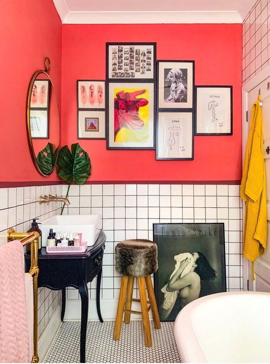 a unique bathroom with red walls, white tiles, pink and mustard textiles and quirky furniture and artworks