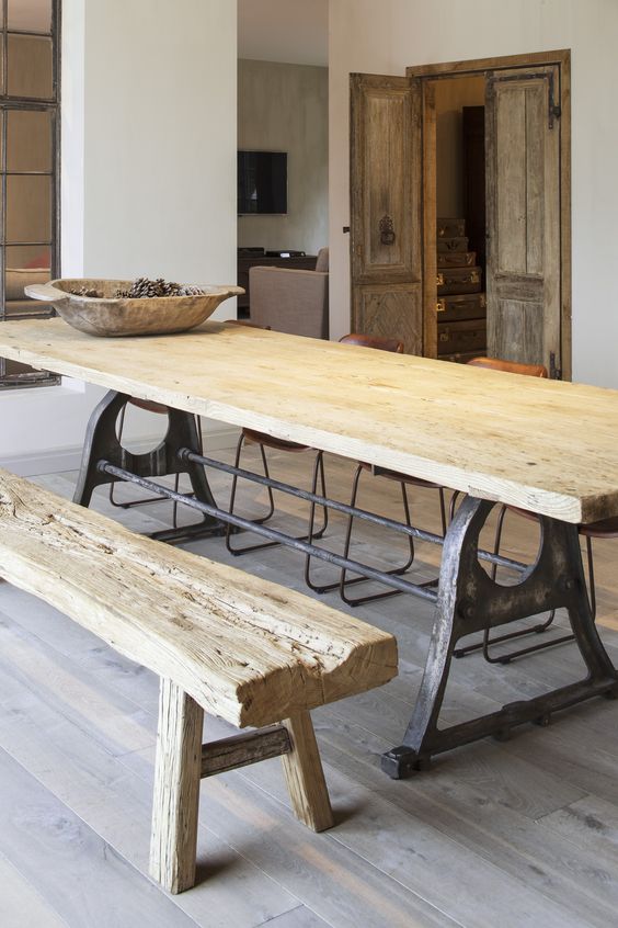 A metal and rough wood dining table plus a rough wooden bench are ideal for a wabi sabi interior like this one