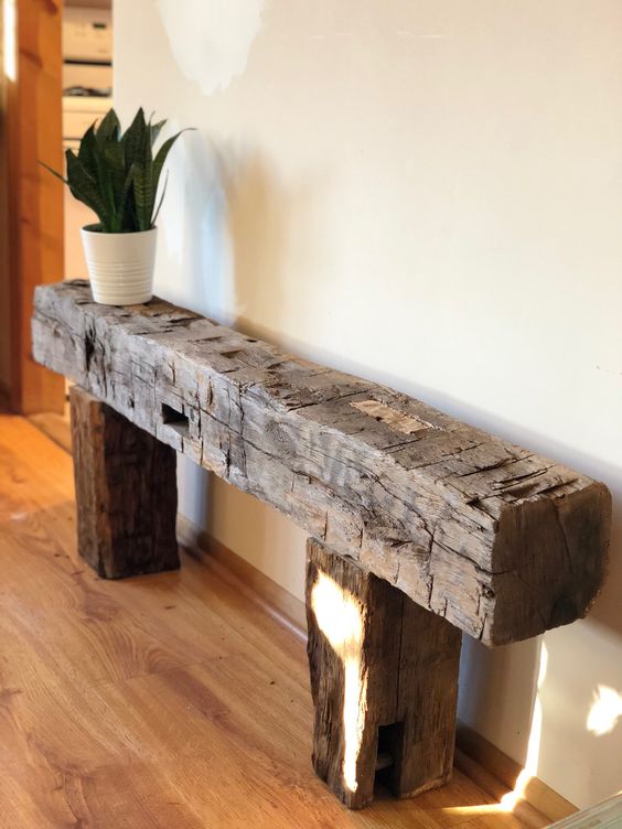 A rough wood console table or bench like this one will be an eye catchy and lovely solution for a farmhouse space or just for a modern one