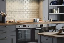 a slate grey kitchen with planks and shaker cabinets, a white subwa tile backsplash, vintage dining furniture
