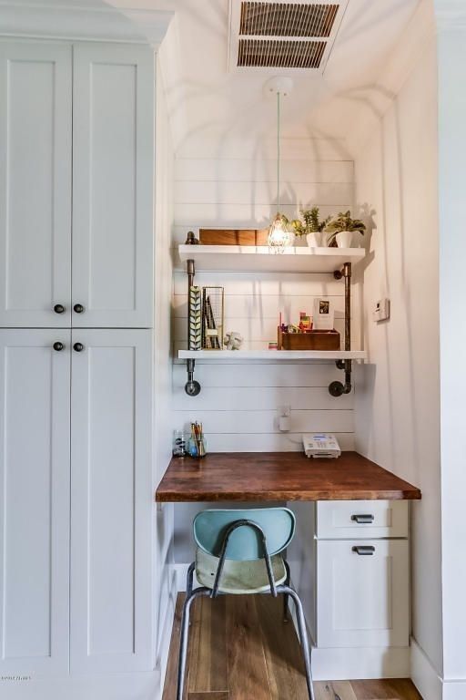 A farmhouse awkward nook done with white shiplap, a built in desk, built in shelves, a pendant lamp and potted greenery for working