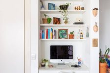 22 a tiny nook with built-in shelves and a desk with a drawer, a white chair, books and potted plants is a cool space fo working