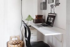 32 a small and lovely nook with a floating desk and a shelf, a black leather chair, a basket and a tiny file cabinet under the desk