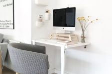 43 a working nook with a two-leg desk, a grey chair, a PC on a stand for more comfort and a series of box-like shelves