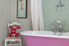 02 an eclectic bathroom with white walls and an aqua tile backsplash, a mauve clawfoot tub, a wooden mat and a shabby chic chair