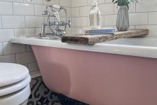 08 a small and pretty bathroom with a printed tile floor, a pink clawfoot bathtub, white subway tiles, greenery and white appliances