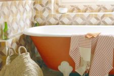 12 a bright bathroom with geometric tiles, an orange bathtub, a printed rug, printed textiles and natural light coming through the window