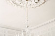a breathtaking white ceiling medallion with petals and a beautiful and airy crystal chandelier with faux candles for a wow look