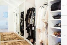 a closet built into a sloped space, with a lot of open storage compartments, shelves and racks, is a great space to get dressed in