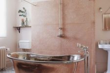 a delicate eclectic bathroom in peachy pink and blush, with a copper bathtub and a vintage chandelier is very welcoming