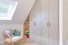 a kids’ playroom with a built-in attic storage unit with wardrobes and open shelves is a very smart solution that saves space
