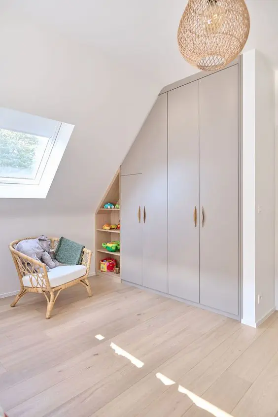 a kids' playroom with a built-in attic storage unit with wardrobes and open shelves is a very smart solution that saves space