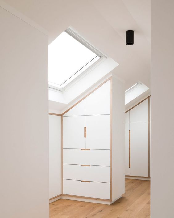 a large attic closet featuring some attic storage units with drawers and skylights to maximize the natural light incoming is a cool idea
