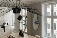 a lovely neutral Scandinavian space with a large and refined ceiling medallion and a chic black chandelier over the space