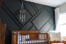 a stylish nursery with a black paneled wall