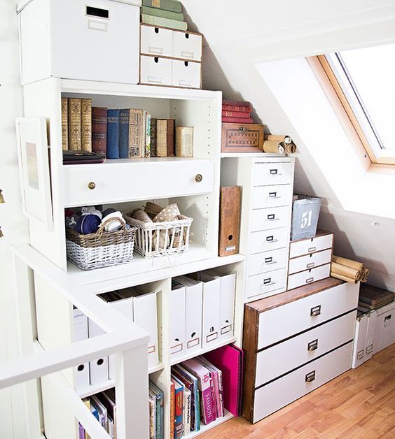A small attic space with built in shelves and dressers plus file cabinets, organized with various boxes and baskets is a cool idea