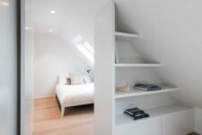 a smart and cool attic storage unit of open shelves and cabinets doubles as a space divider at the same time