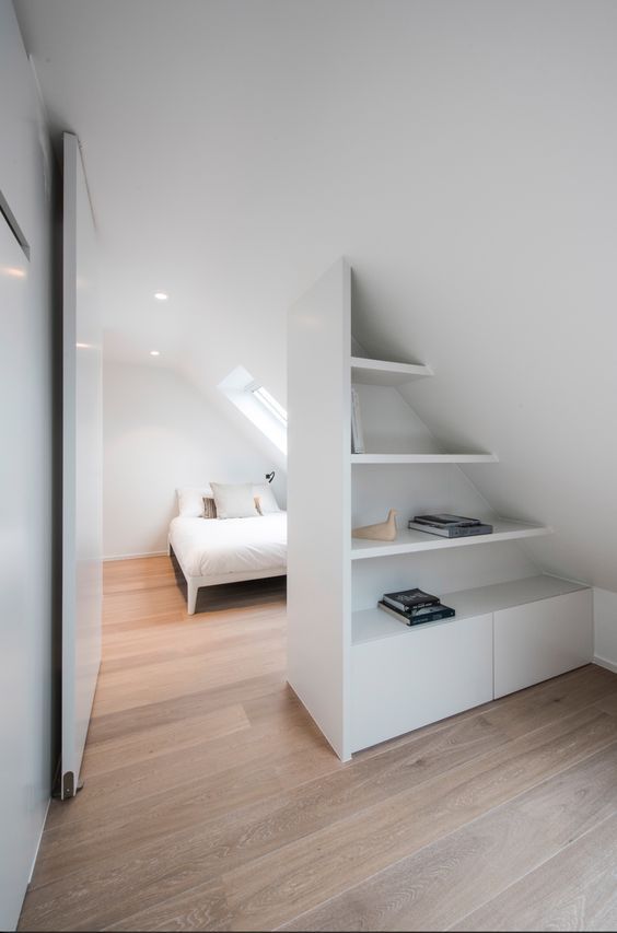 a smart and cool attic storage unit of open shelves and cabinets doubles as a space divider at the same time