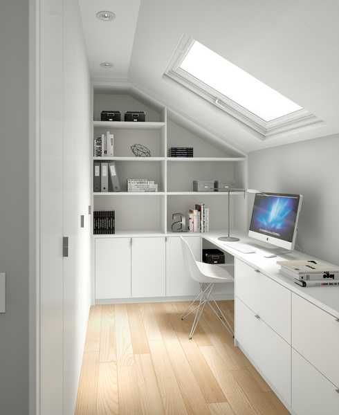 A white attic home office with a built in storage unit, a skylight and a storgae unit with a built in desk is a smart solution