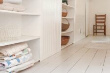 an attic built-in storage space with open shelves and shiplap is a cool idea for a cottage or a farmhouse space in neutrals