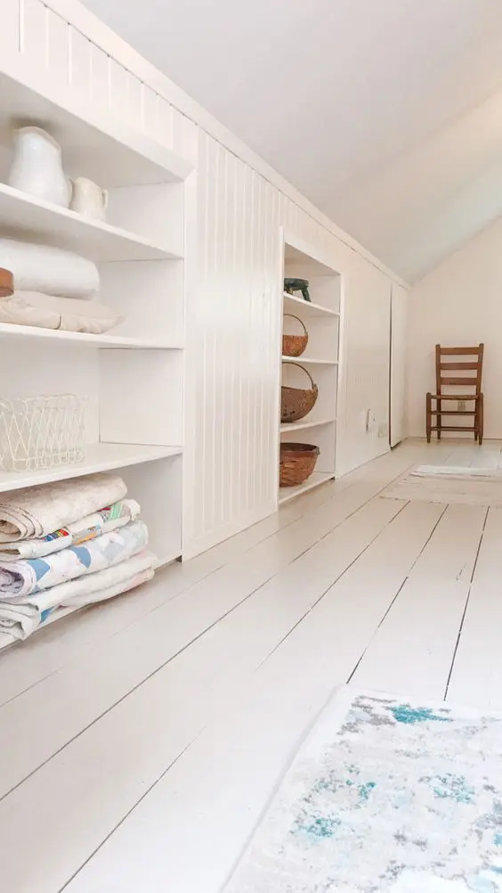 An attic built in storage space with open shelves and shiplap is a cool idea for a cottage or a farmhouse space in neutrals