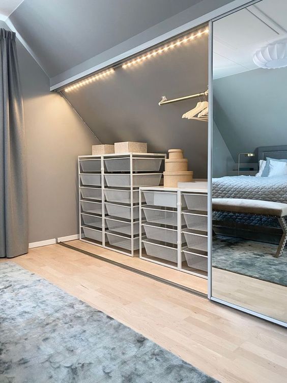 an attic nook with mirror sliding doors and storage cubs, boxes and railing inside is a smart solution to organize your space