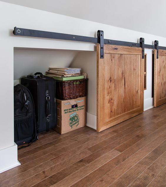 An attic space with built in storage compartments that are hidden with barn doors is a very smart idea to rock