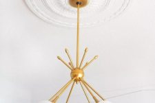 an elegant and pretty simple ceiling medallion and a mid-century mmodern chandelier with a gold base and forsted glass lampshades for a refined look