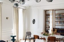 an oversized beautiful ceiling medallion formed of pieces attached right to the ceiling and a stylish mid-century modern chandelier with smoked glass