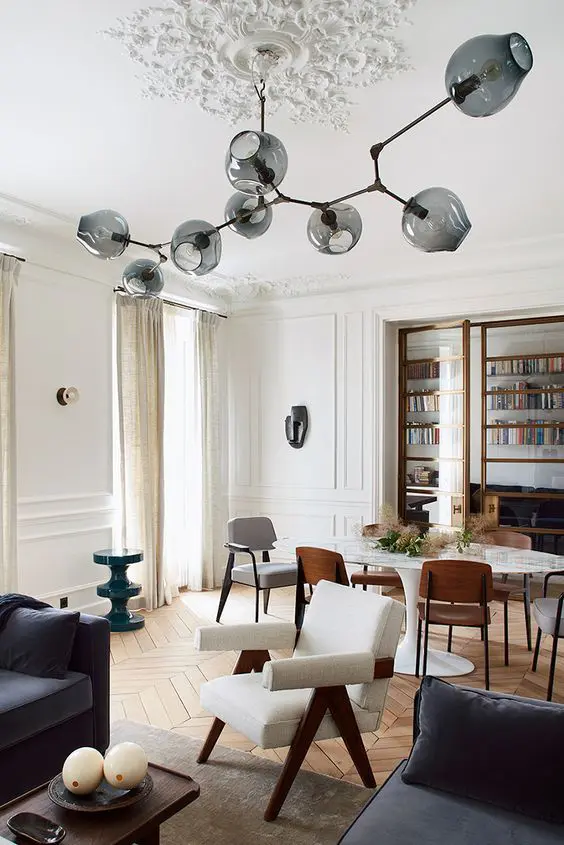 An oversized beautiful ceiling medallion formed of pieces attached right to the ceiling and a stylish mid century modern chandelier with smoked glass