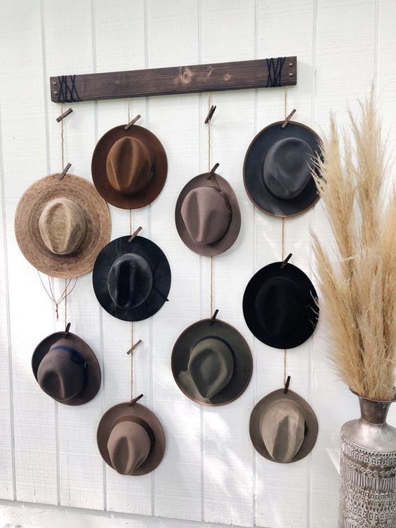 a hat organizer made of a stained piece of wood, with ropes where you attach your hats with clothespins is a lovely idea for a rustic room