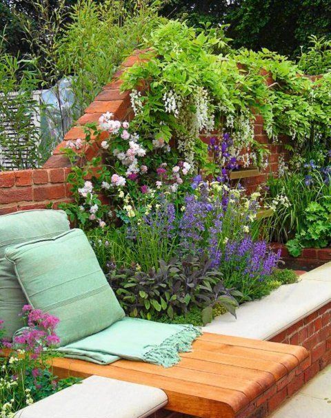 raised brick garden beds along the fence match it and match the space, and a built-in lounger with pillows is a great idea to relax on