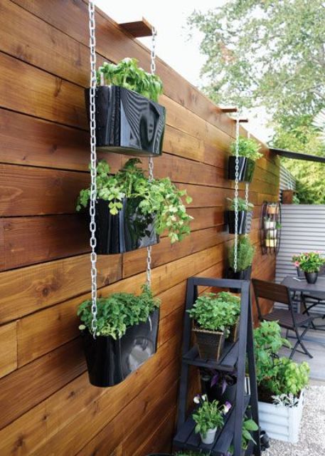 tiered vertical planters with greenery and a ladder with planters are a simple and cool way to refresh the space and make it greener