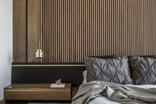 03 a contemporary bedroom with a wood slat accent wall, a black bed with extended headboard, neutral bedding and a floating nightstand