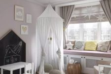 04 a delicate and subtle Scandi nursery with blush walls, a large windowsill bench with pillows, a bed with neutral bedding and a teepee