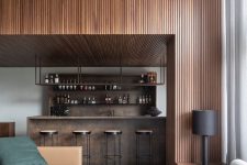 05 a contemporary home with a wood slat accent wall and a ceiling, a timber home bar and stylish contemporary seating furniture