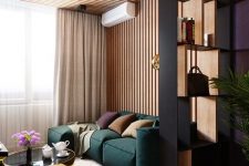 06 a contemporary living room with a wood slat accent wall, a green low sofa, elegant and shiny coffee tables and a shelving unit space divider