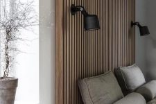 12 a contemporary neutral bedroom with a wood slat accent wall that features a couple of sconces, a grey upholstered bed and grey bedding, a potted plant