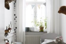 16 a small and cute kid’s room with a grey bed, an open storage unit, polka dots for an accent and baskets