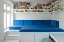 19 a small kid’s space with open shelves, a raised sofa to sleep on, storage drawers and a built-in desk and bright touches