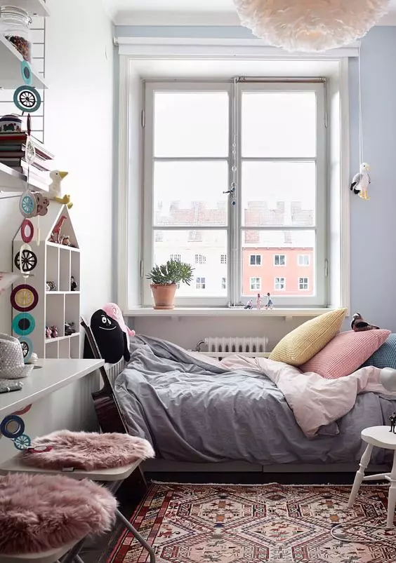 a welcoming small Scandinavian kid's room with a bed, a floating desk and stools, a house-shaped wall-mounted shelf, a pendant lamp and a printed rug