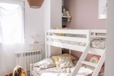 27 a beautiful mauve kids’ bedroom with a bunk bed, a jute rug, a storage unit and open shelves plus a two-tone lamp