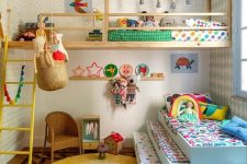 28 a colorful shared kids’ room with a raised bed and a bed at the window, some ladders, a wicker chair and colorful bedding and toys