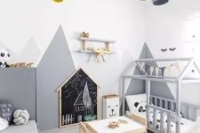 30 a fun and cool Scandinavian kids’ room with two beds, walls with mountain art, pendant lamps, wooden boxes with stars