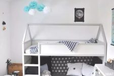 32 a Scandi kids’ room with a bunk bed, printed bedding, a striped rug, a white table and chair, a white storage unit